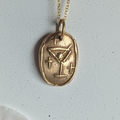 Gold necklace with a pendant on a white background with pink petals